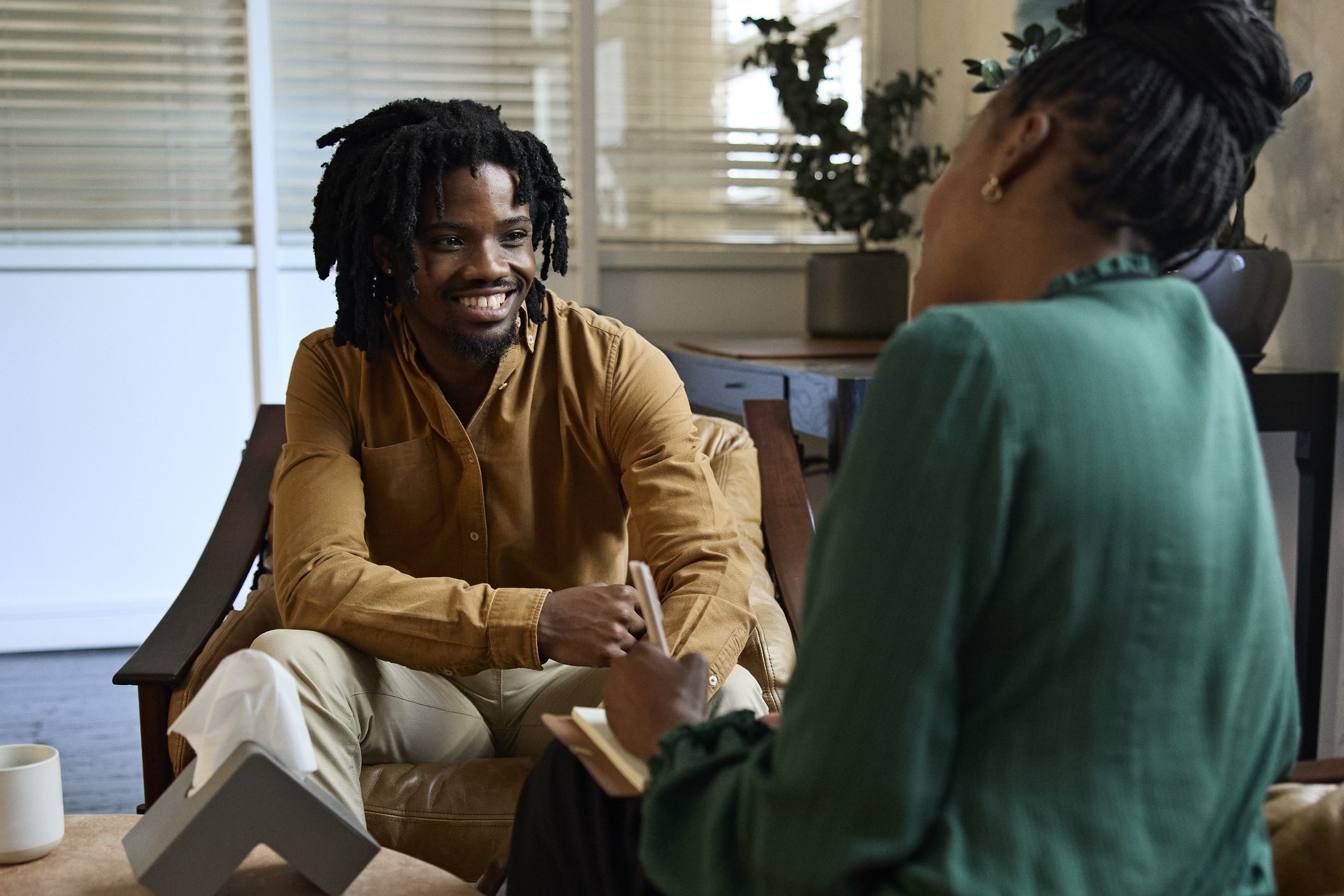 Smiling young businessman talking with female therapist A Welcoming Behavioral Health Center in Atlanta